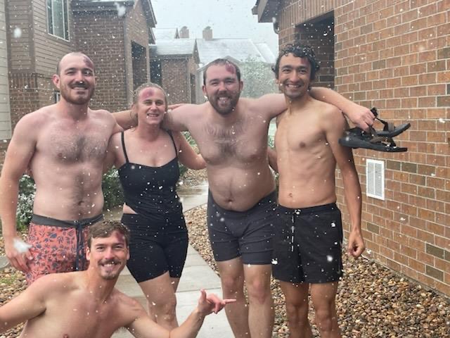 Rose Savage Levenson, BaMidbar's Program and Operations Coordinator, is pictured with a group of wilderness first responder trainees. They are grouped together, smiling for the camera. Snowflakes are falling in the foreground.